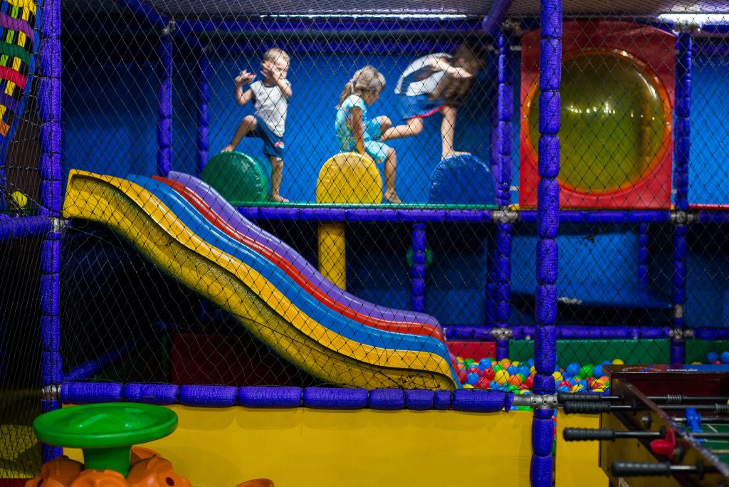 crianças de ferias - Crianças brincando no espaço kids da Officina Cervejaria com piscina de bolinhas e escorregadores.